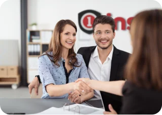 Couple shaking hands with insurance agent.