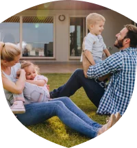 Family sitting on the grass outside their home
