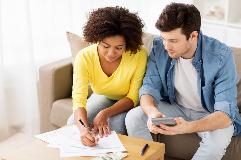 man and woman filing taxes together on living room