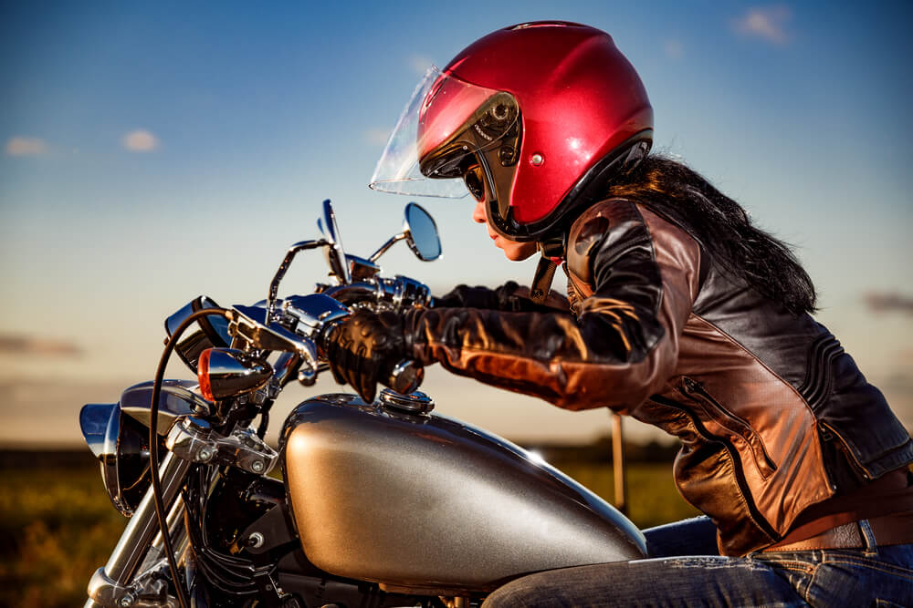 woman riding motorcycle with red helmet