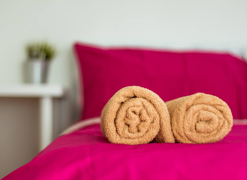 towels on bed in airbnb room home sharing insurance