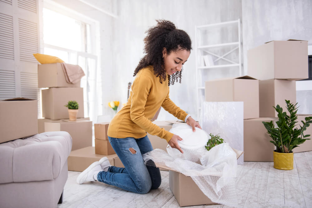 happy girl unpacking plates in new apartment rental insurance