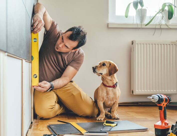 man doing home reperations with a dog diy home projects