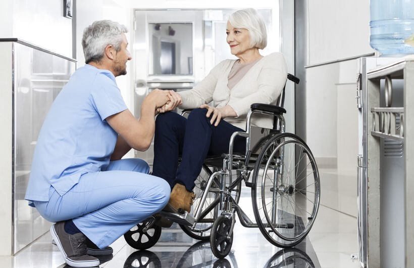 doctor taking care of elderly woman on wheelchair long term care coronavirus