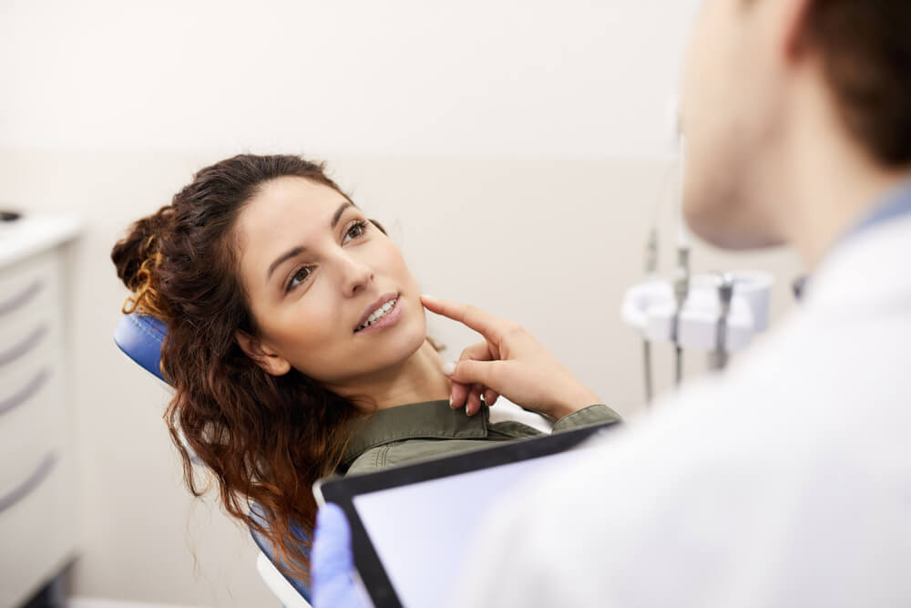 woman at the dentist chair asking how does dental insurance work