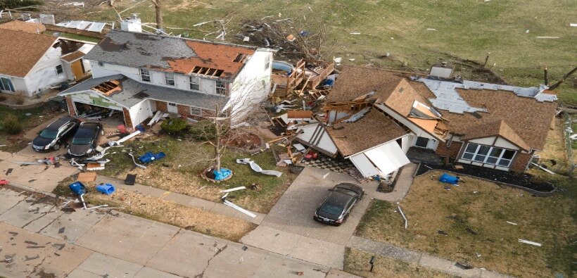 Aerial view of tornado-damaged homes and debris in a residential neighborhood, illustrating tornado home insurance claims and storm damage coverage.