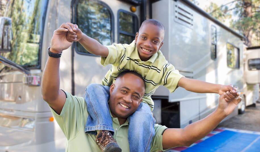 african american father and son enjoying a used travel trailer