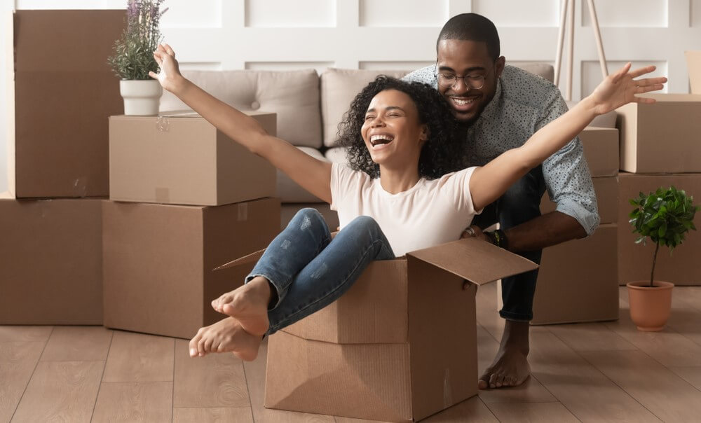 happy couple playing with moving boxes while renting for the first time