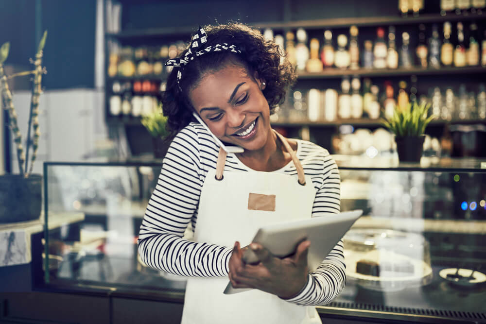 african american woman talking on the phone running her small business with insurance
