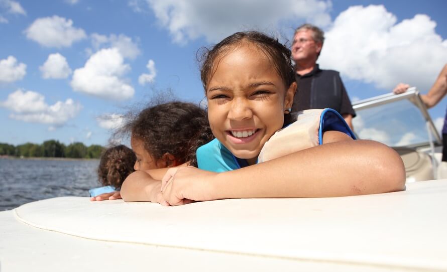 happy little girl on boat with watercraft insurance