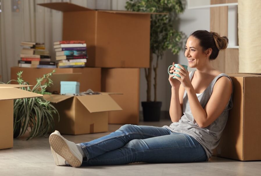 happy woman sitting in her rented apartment