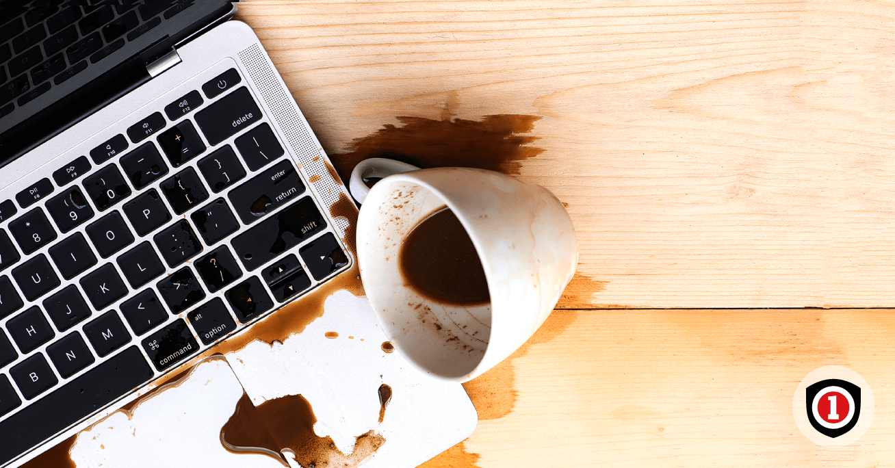 A cup of coffee spilling on computer