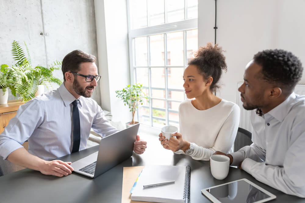 young couple with insurance agent looking at the types of life insurance at office