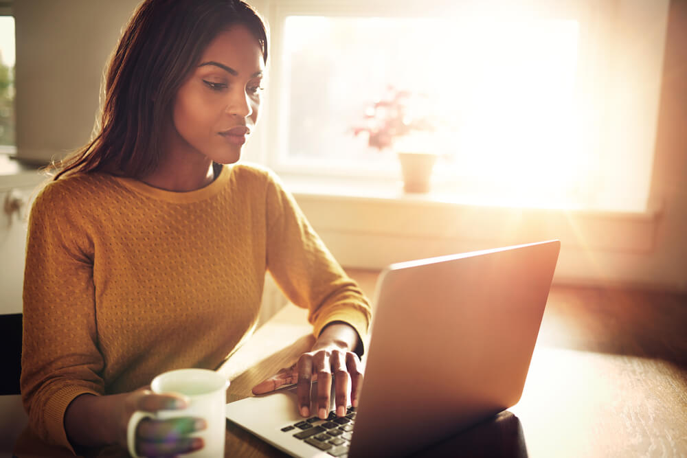 young african american woman looking at the types of homeowners insurance in laptop