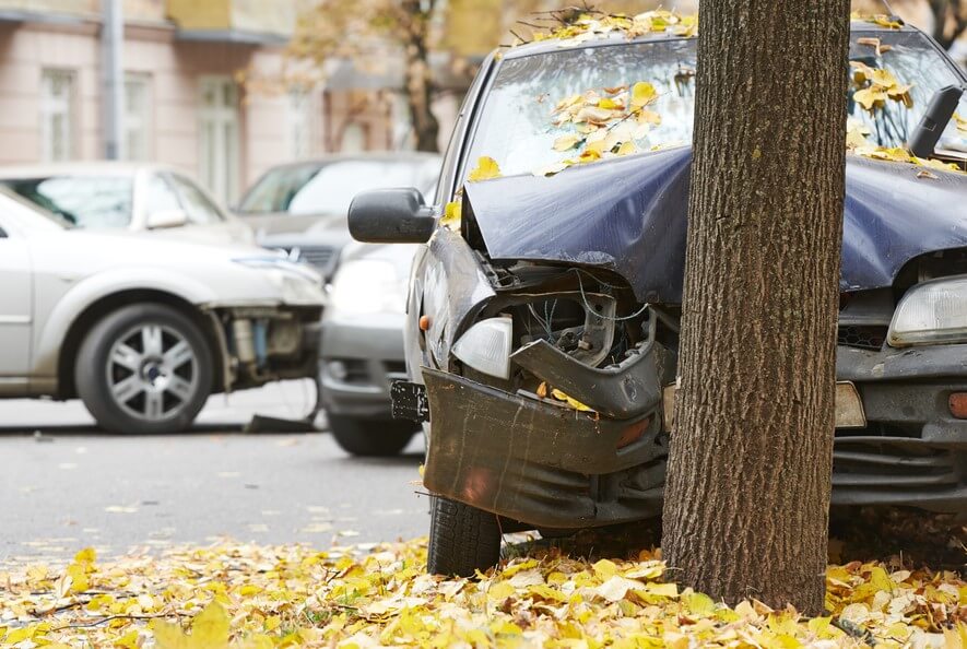 front view of car crashed into tree with full coverage insurance