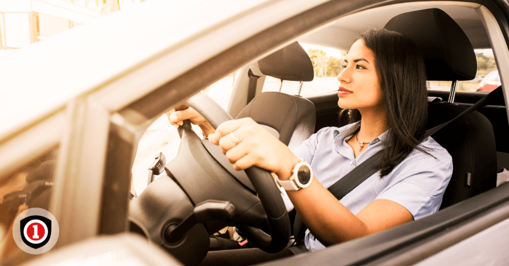 A Hispanic woman driving her car while is covered by Gap Insurance