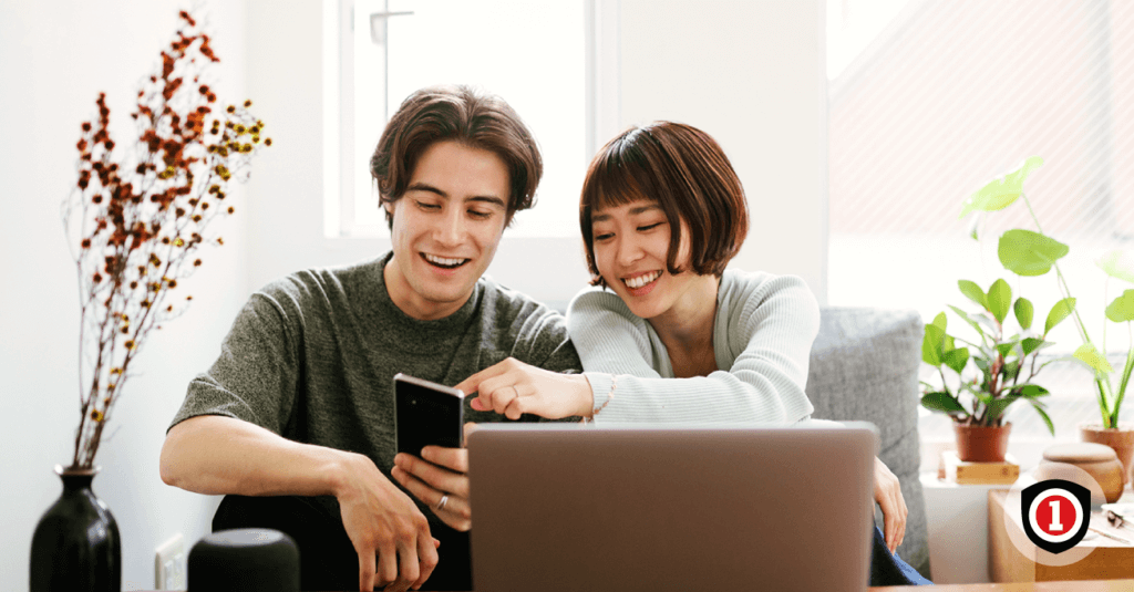 An Asian couple looking for affordable renters insurance on the computer and cellphone