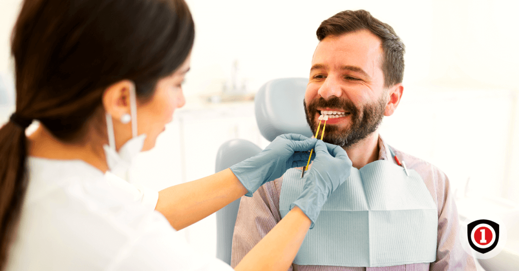 A man smiling while he's with his dentist