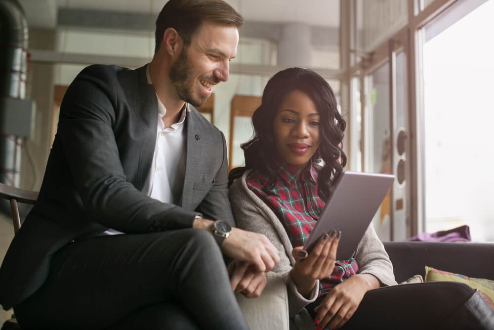 man and woman in cafe looking at tablet for homeowners insurance