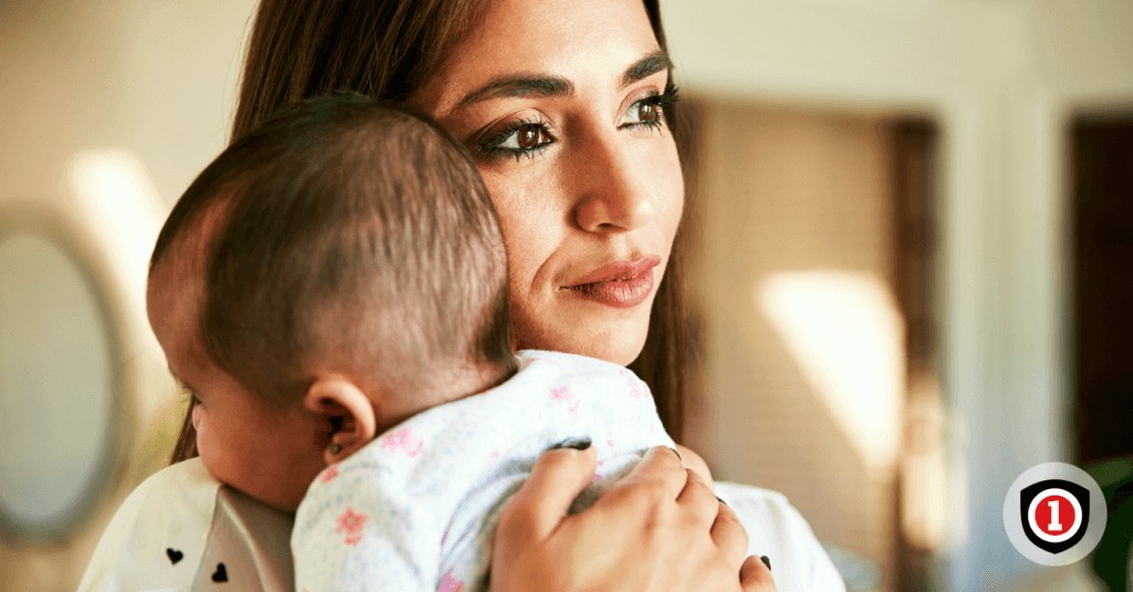 A mother holding her baby while enjoying newborn insurance. 