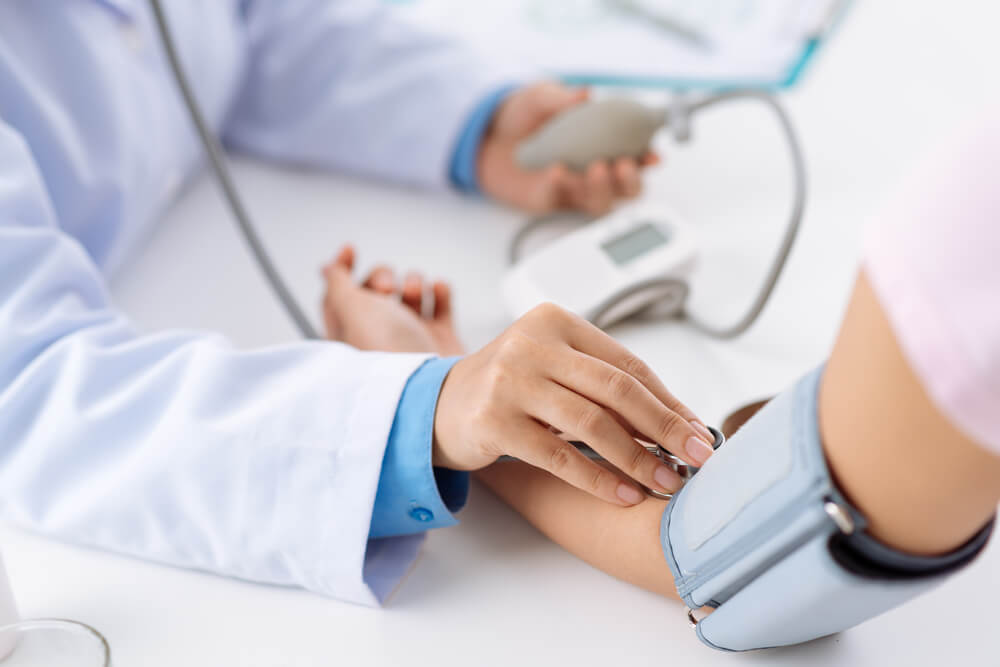 doctor taking blood pressure of patient