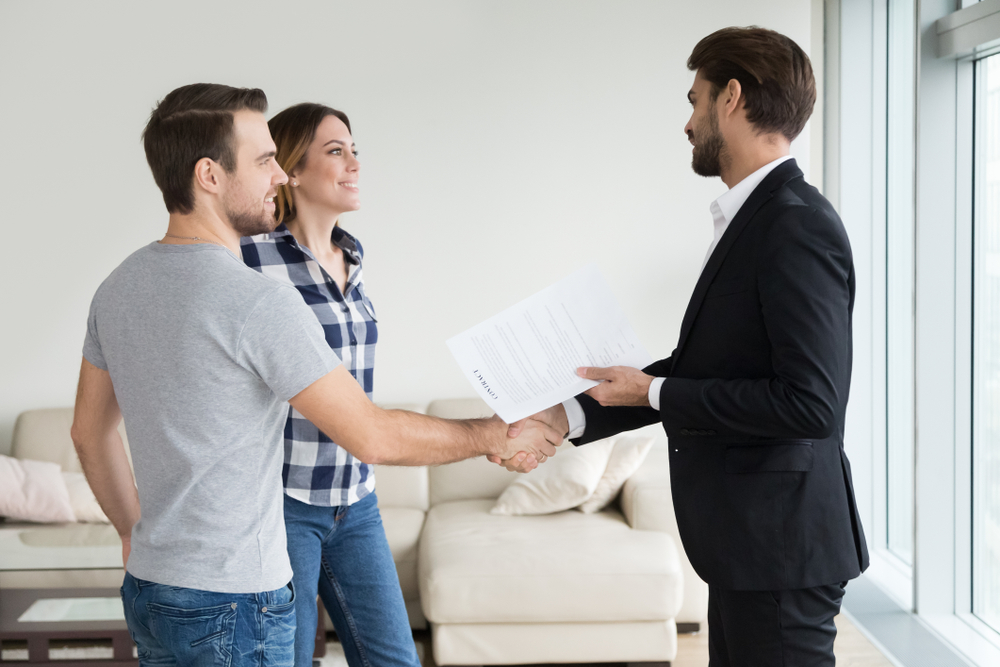 landlord shaking hands with new tenants