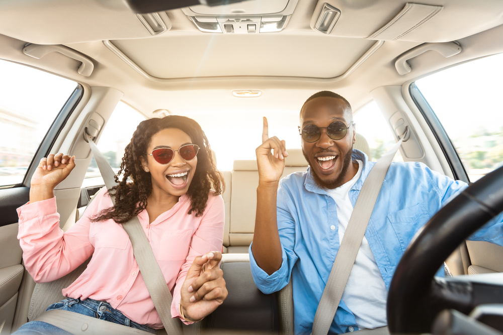 young college couple smiling in car