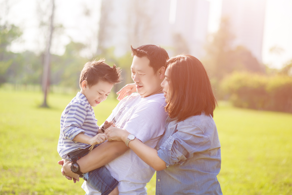 Parents,With,Their,Child,In,The,Field.,Happy,Family,Life young asian couple holding child
