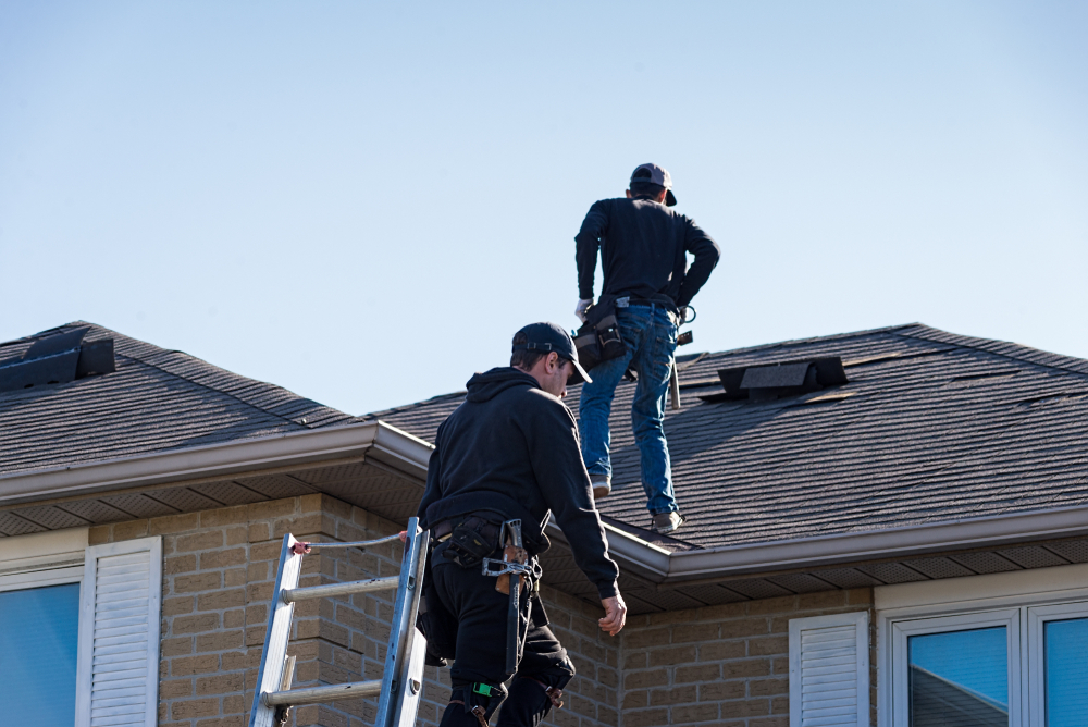 roofers inspecting damage to roof
