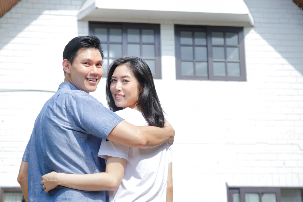 Asian,Male,And,Female,Couples,Stand,,Hug,,And,Smile,Happily young asian couple smiling with arms around one another