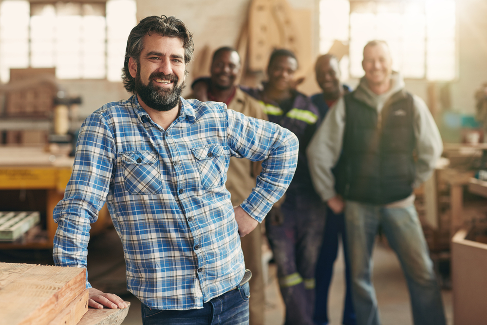 smiling business owner standing in front of employees