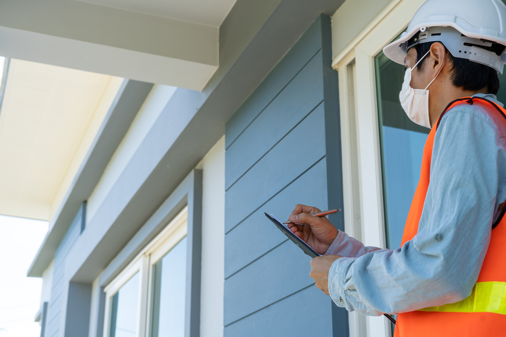 home inspector standing outside of house