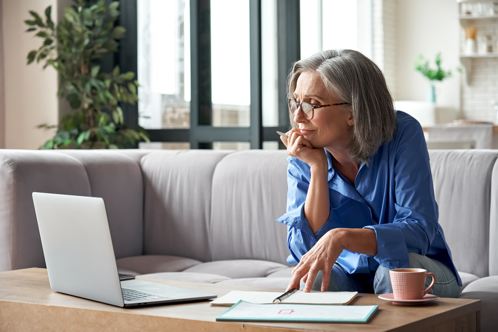 retired woman in living room with laptop