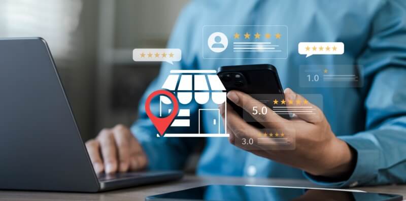 Business owner reviewing online business listings and customer ratings while managing a second location, illustrating ways a second location affects commercial insurance.
