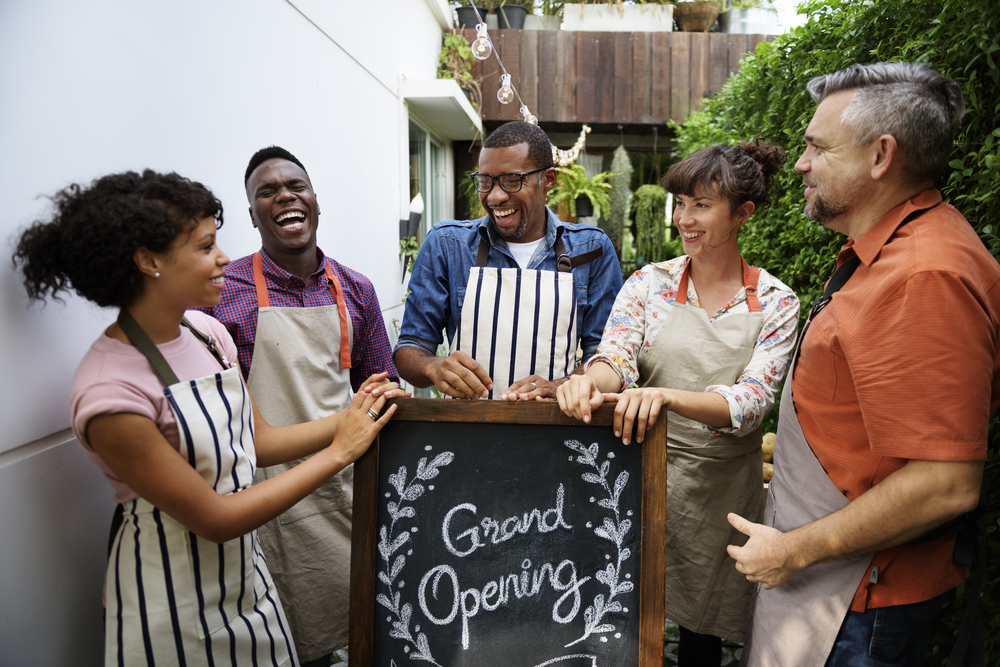 A group of diverse happy people celebrates a grand opening