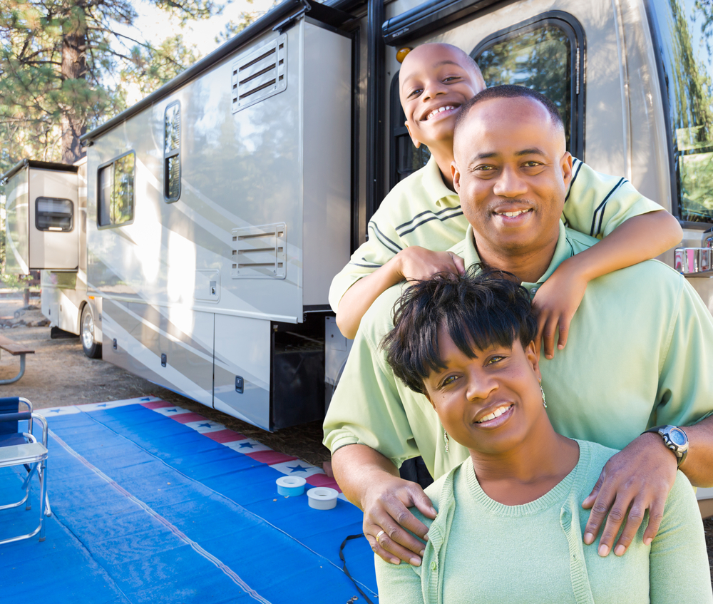 Happy African-American family outside of their RV in the campground
