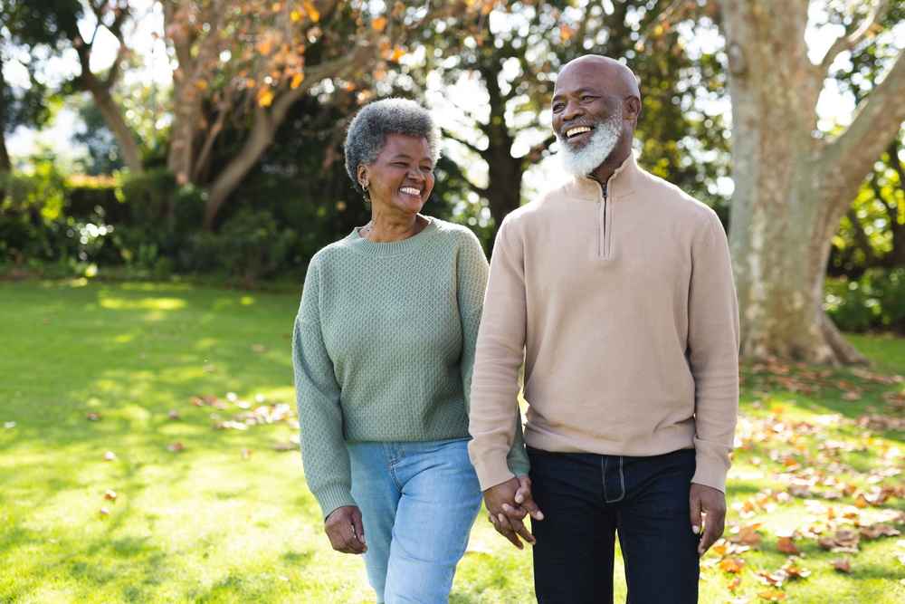 Senior African American couple smiles and walks 