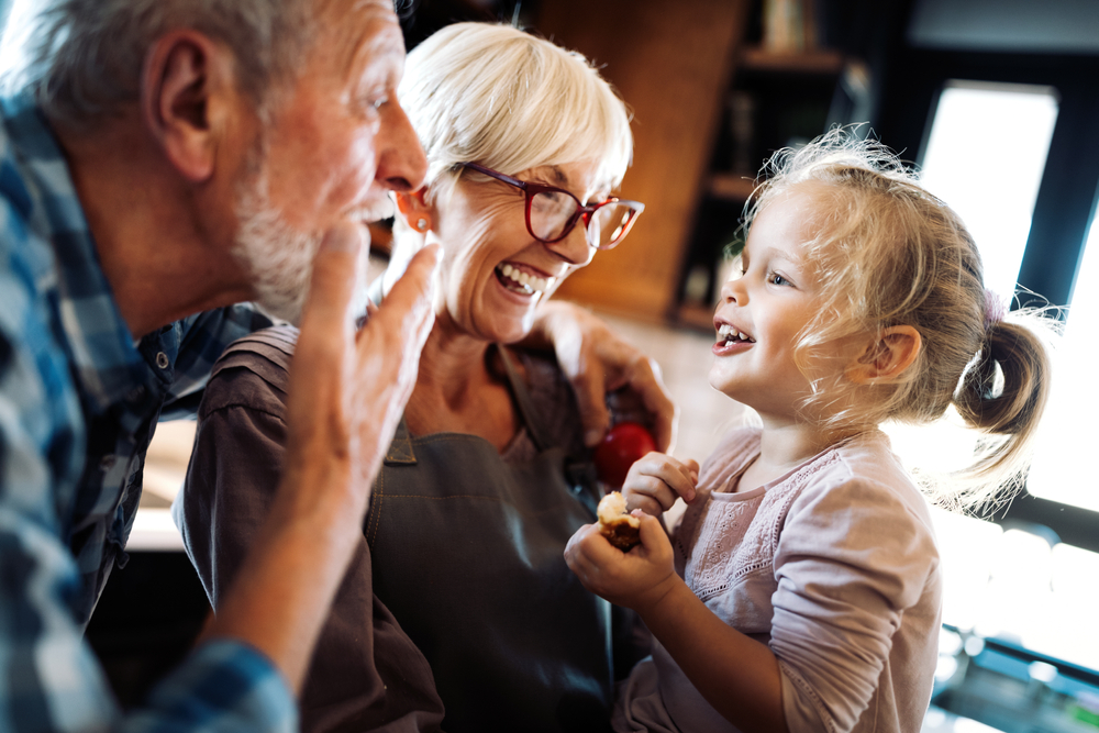Senior grandparents having fun with their grandchild while contemplating life insurance