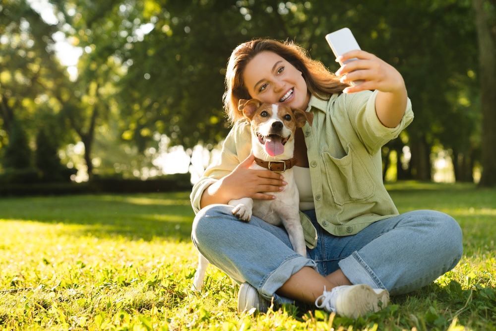 Woman takes a selfie with her pet in the park