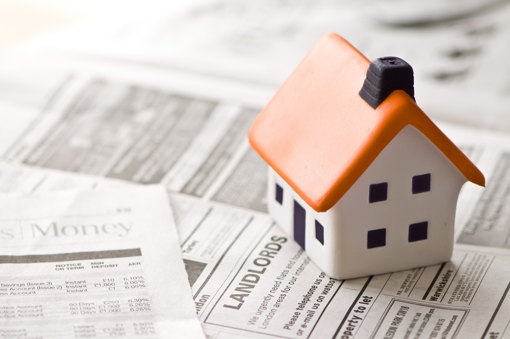House,To,Sell Concept of landlord insurance with small home sitting on landlord contracts