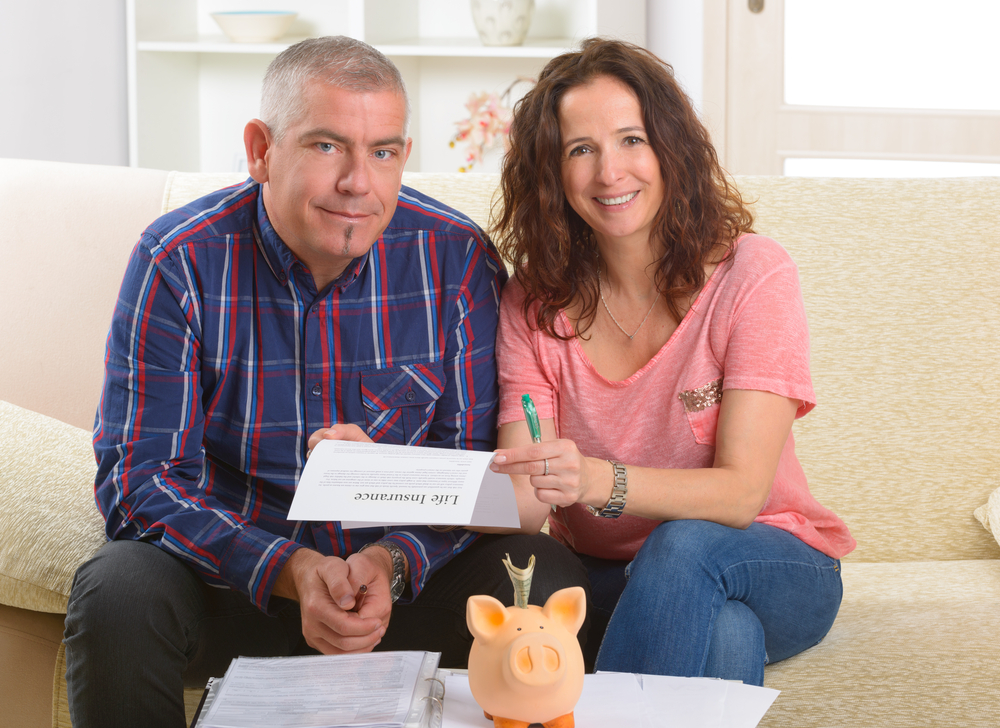 Smiling couple signing life insurance policy - best life insurance