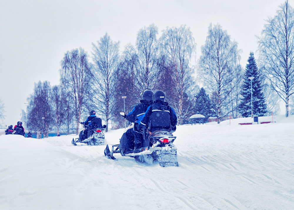 Couple snowmobiling through the snow