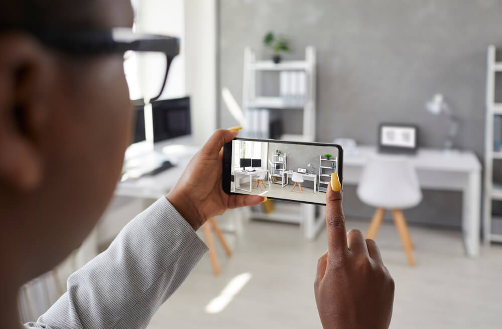 Male renter takes a photo of his computer set up with his phone to document the value of his belongings.