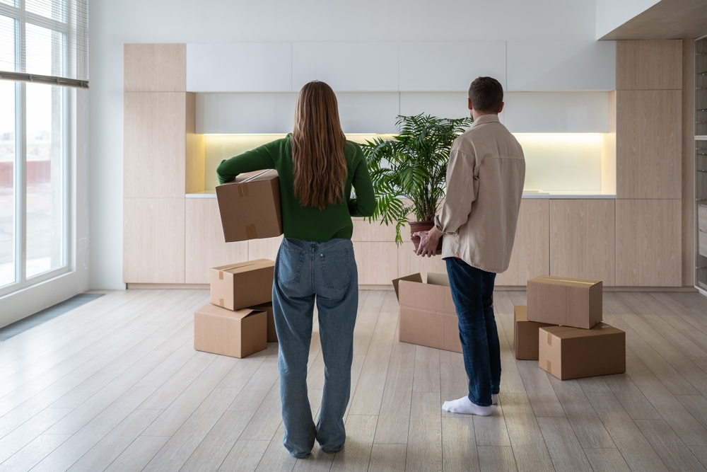 Couple with boxes moving into their rental after signing contract to rent to own the property. Good thing they have proper renters insurance