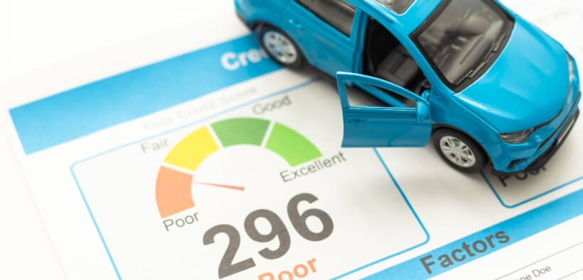 Blue toy car on a credit score report showing a 296 score and rating gauge, illustrating credit score impacts car insurance rates.