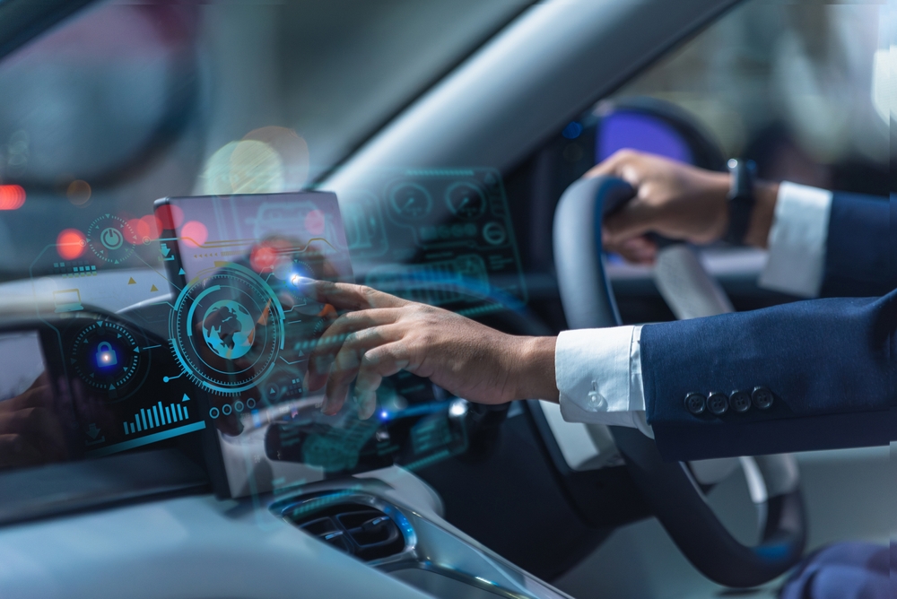 Driver using a connected car touchscreen, illustrating the Future of Car Insurance with smart vehicle technology.