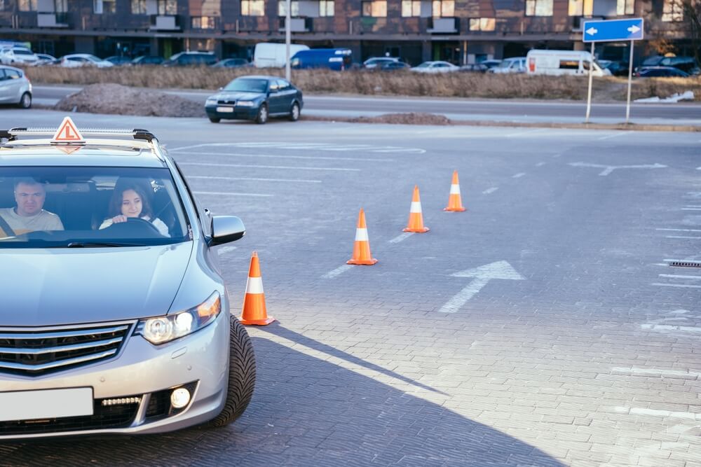 Teen driver practicing with cones under supervision, representing training required before getting teen driver car insurance coverage.