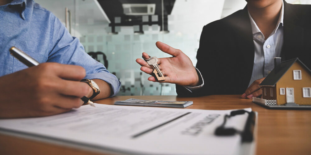 Renter receiving house keys while reviewing factors that can affect renters insurance rates.