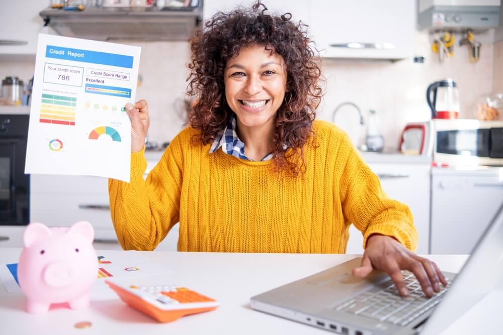 ino-how-bundling-insurance-can-enhance-your-credit-score-1 Happy woman checking her good credit score online, improved her credit score by bundling her insurance.