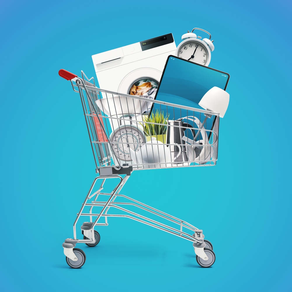 Shopping cart full of household goods, appliances and electronics: sales and retail concept.
